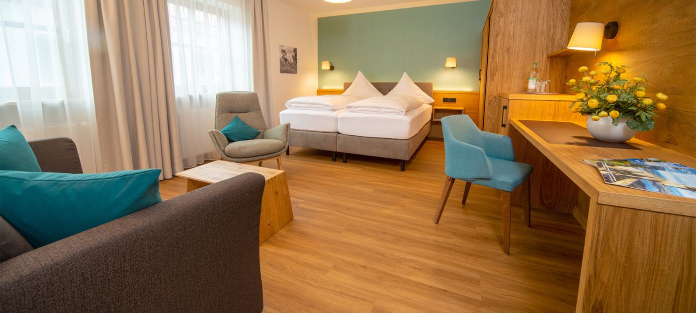 Doppelzimmer mit Sofa und Schreibtisch