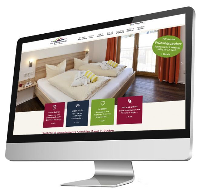 Das Bild zeigt einen iMac, auf dessen Bildschirm die Webseite eines Seehotels & Apartments namens „Scholler Garmi in Rieden“ zu sehen ist. Die Webseite präsentiert ein Foto eines gemütlich bezogenen Hotelbettes mit Blick auf ein Fenster und orangefarbene Vorhänge. Im Vordergrund der Webseite befinden sich außerdem farbige Kästen mit Informationen zu Online-Buchungen, Lage & Aktivität, Angeboten und Wellness. Ein Banner bewirbt einen „Frühlingszauber“-Aufenthalt.